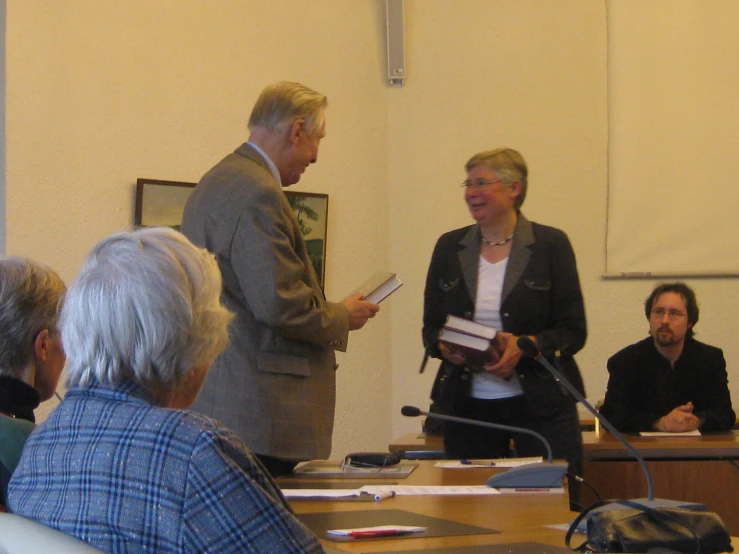 two men and a woman standing in front of a podium