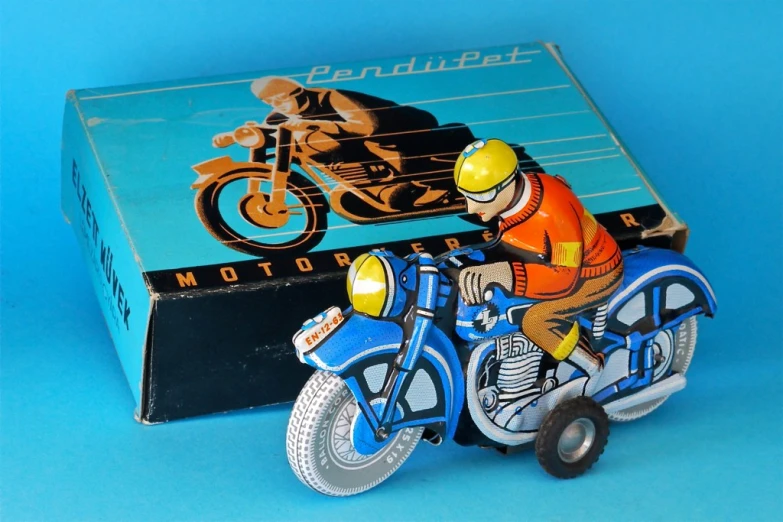 a toy figurine in an orange shirt on a motorcycle