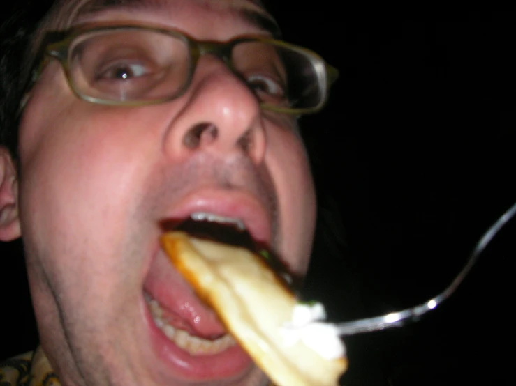 a close - up of a man with a tooth brush sticking out of his mouth and food sticking out of his mouth