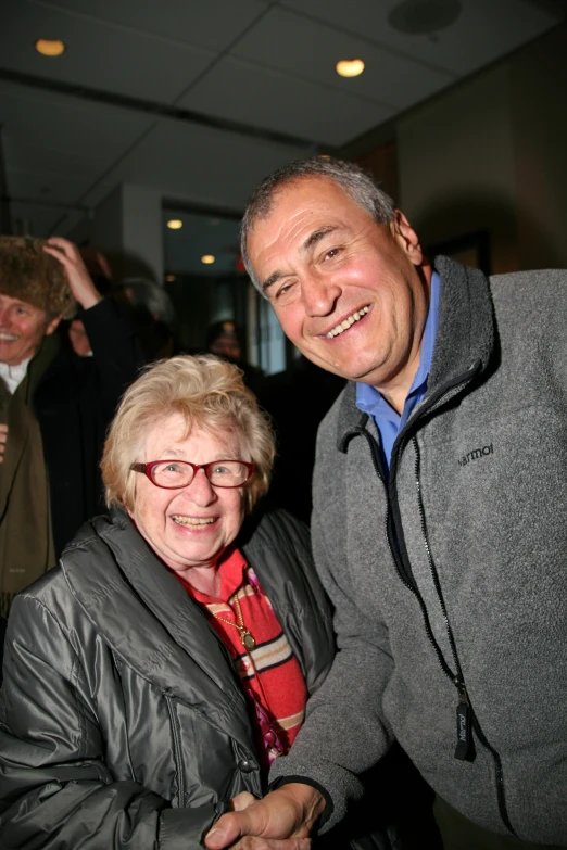 two men smile together at an event