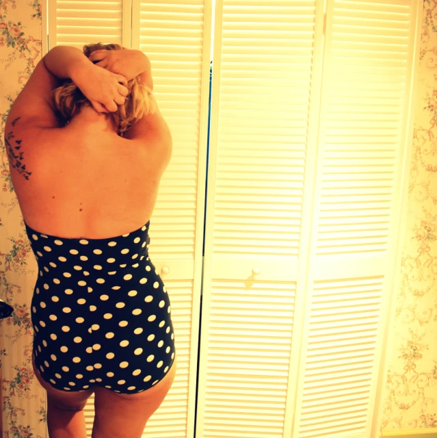 the back of a girl in a polka dot bathing suit