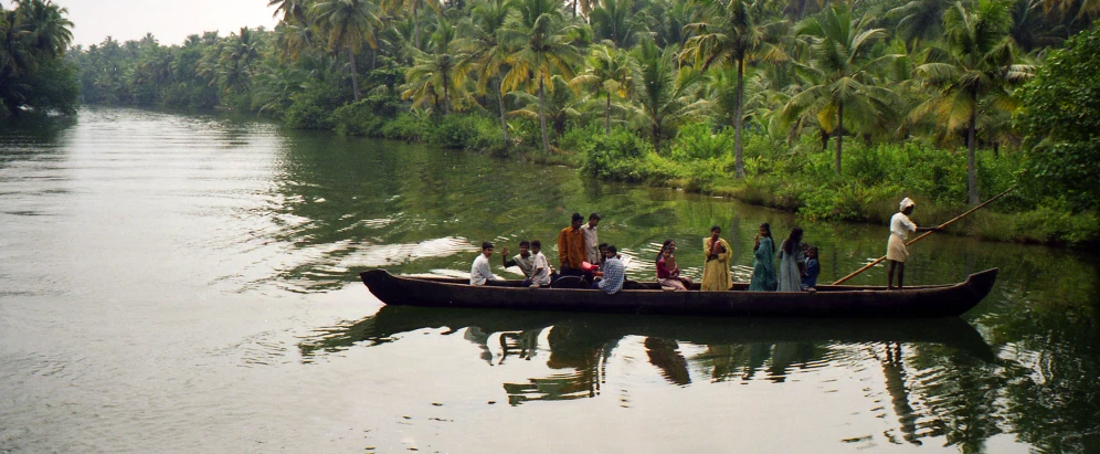 several people are riding in a long boat