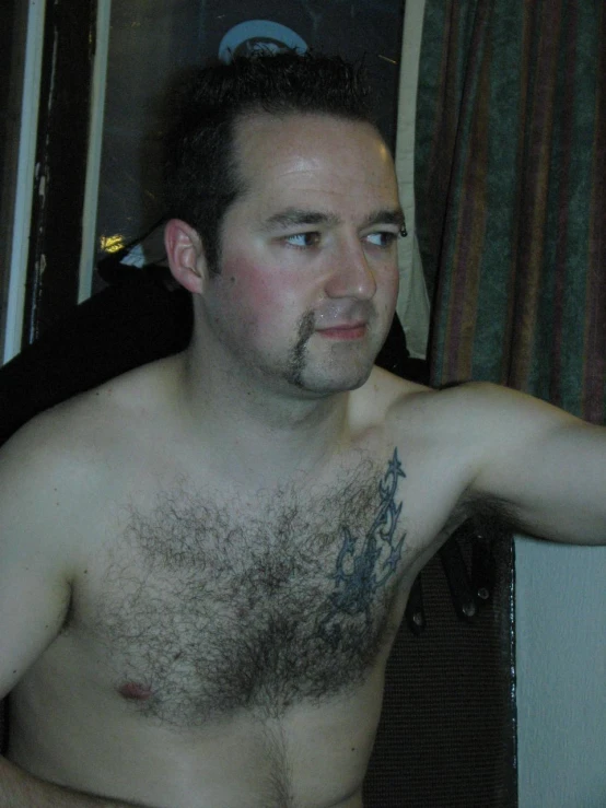 a man with tattoos on his chest with 