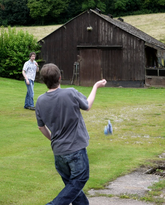 three young people are playing catch in a field