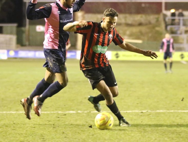 two soccer players vie for the ball during a game