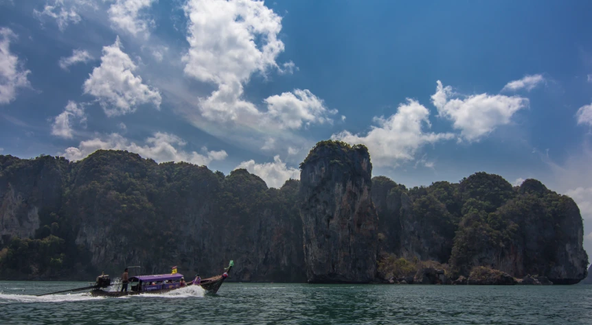 people are in a boat moving towards some rocks