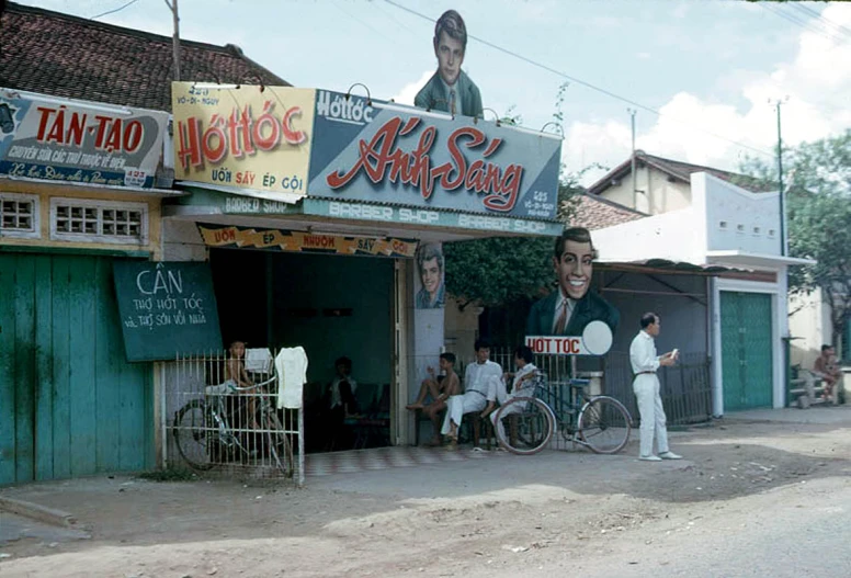 a man holds a sign in front of a building with a giant face