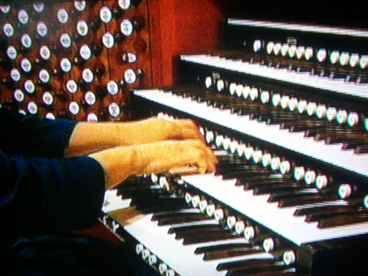 a person sits at the organ and points to ons