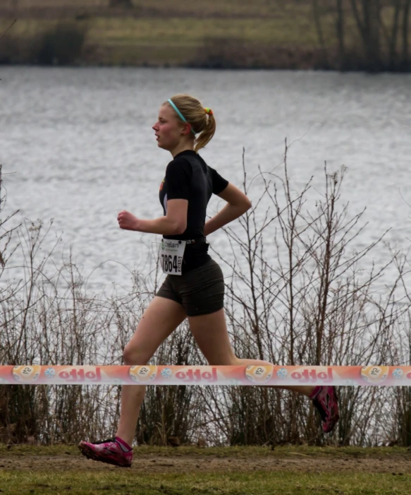 a female running beside the water on a sunny day