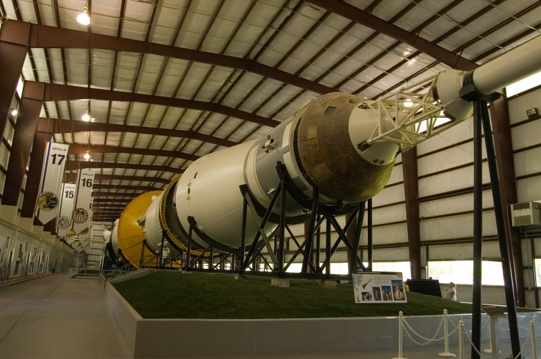 a white rocket on display inside of a large building