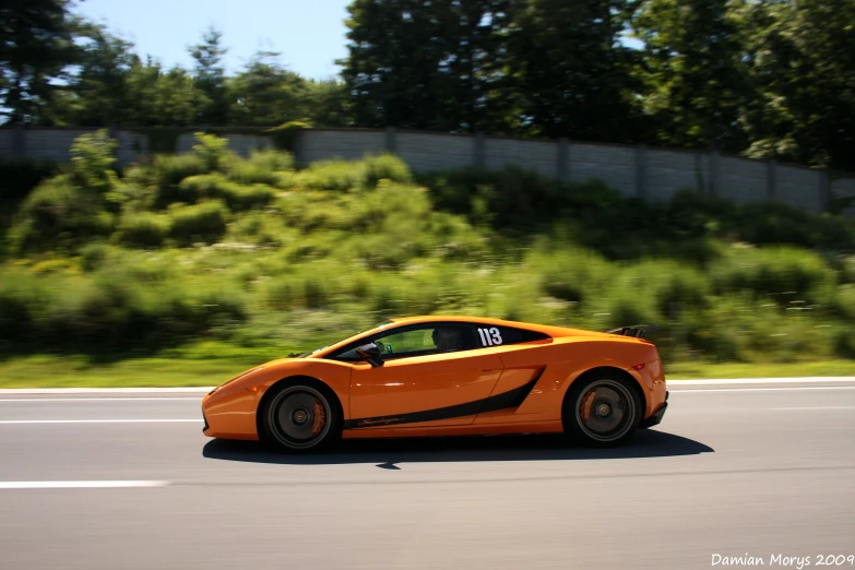 a sport car drives down the road during daytime