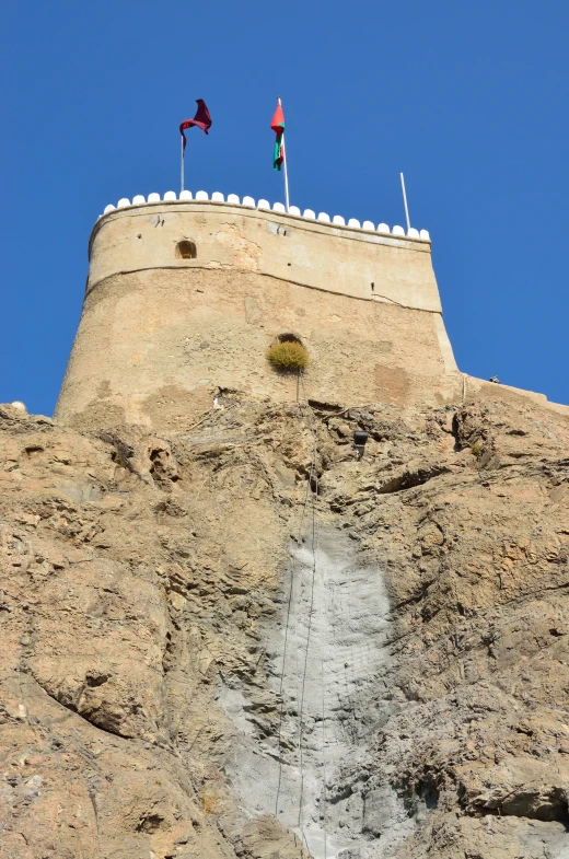 two flags on top of a tall mountain