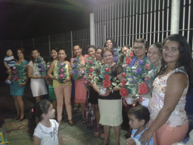 a group of women are standing and smiling in front of some steel fence