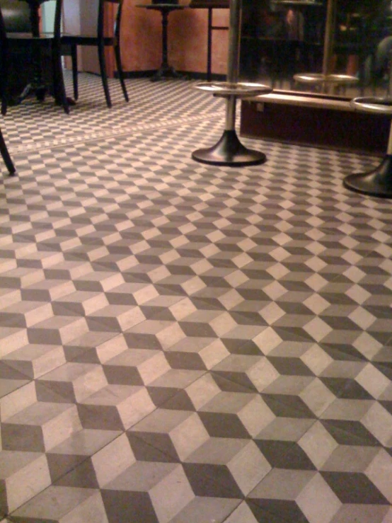 checkered tile in an empty bar with several wooden tables