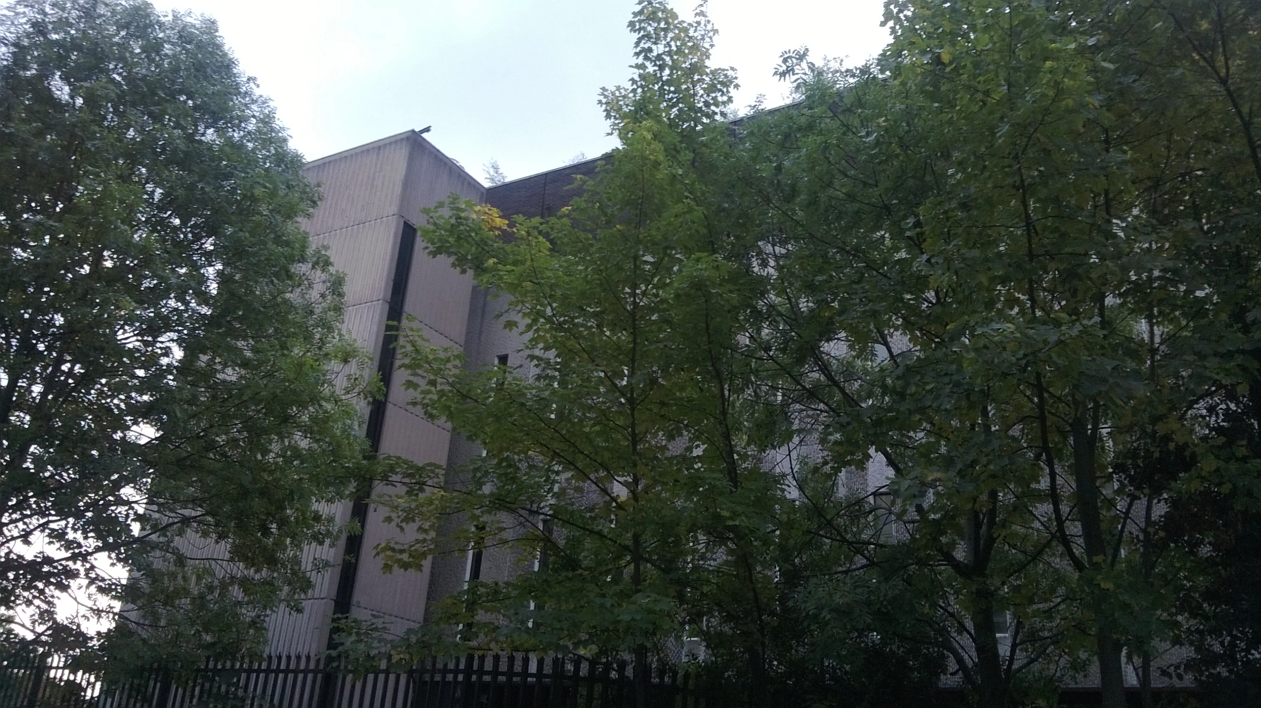 a clock on the top of a building surrounded by trees