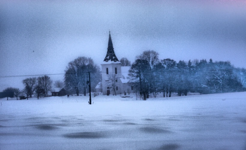 a church in the snow with a clock tower on it