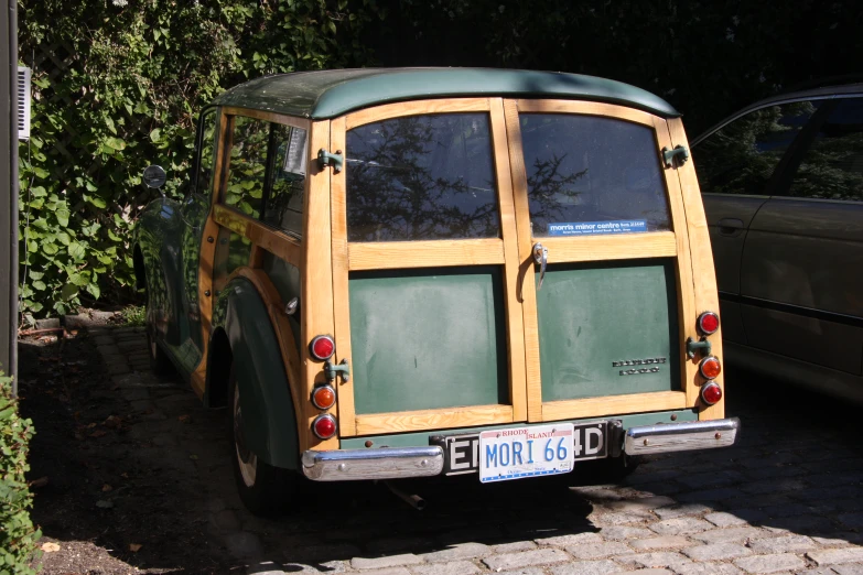 a green minivan sitting next to a car parked on the side of a road