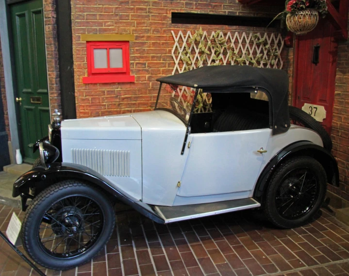 a vintage car sitting in a doorway on a brick building