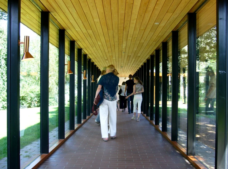 people walk along the walkway of a wooden building