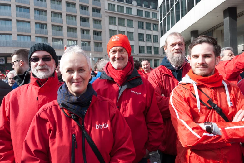 some people dressed in red jackets are standing together