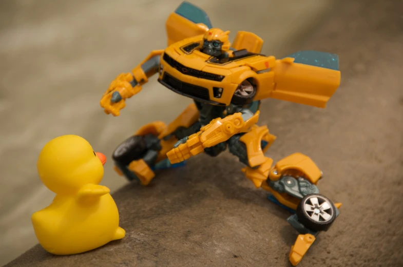 a plastic toy duck and robot with yellow body