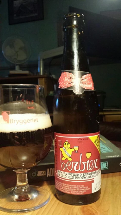 a beer bottle and a glass sitting on top of a wooden table