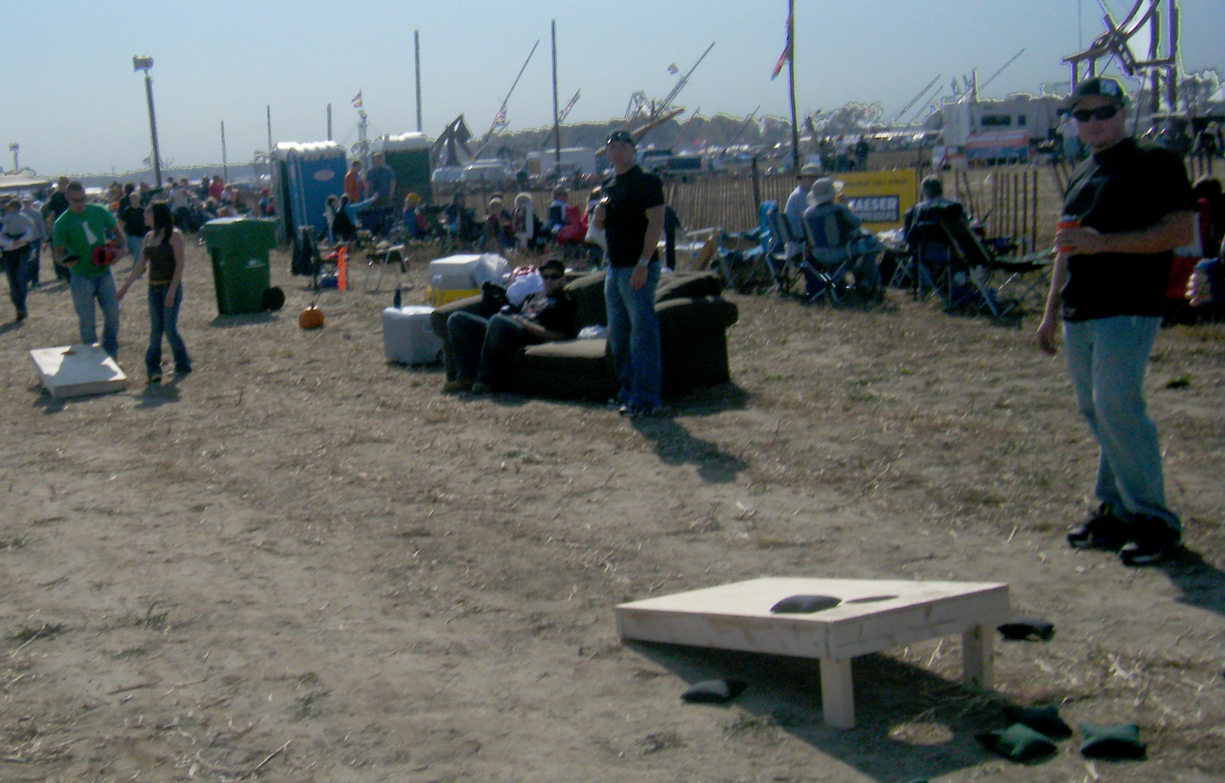 a bunch of people standing in the sand on a beach