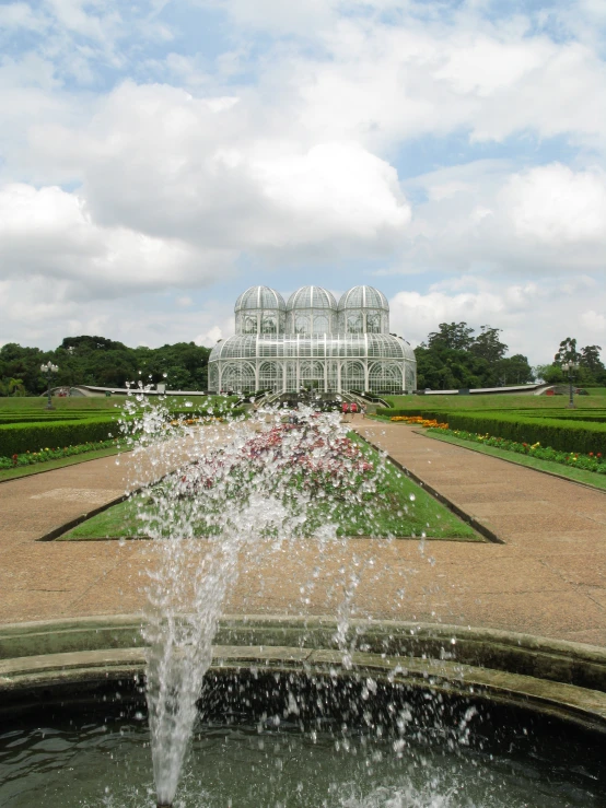 the fountain is spouting water into a garden