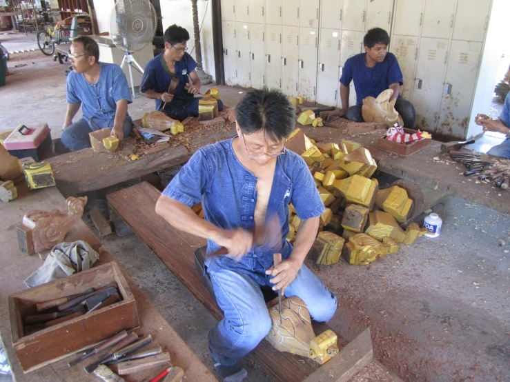 a group of men working together to make items