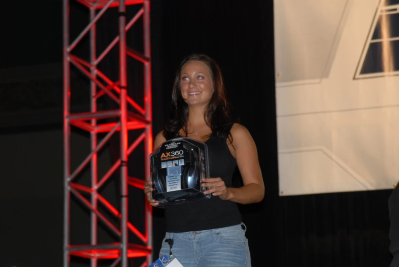 a woman is smiling holding up an award