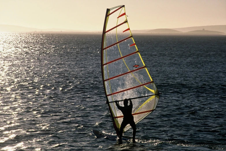 a man riding a windsurf across a body of water