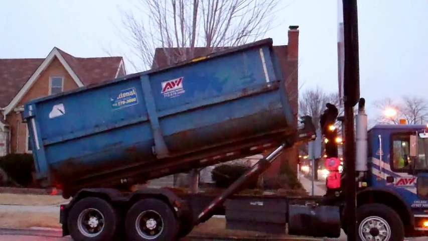 a blue dump truck parked at a traffic light