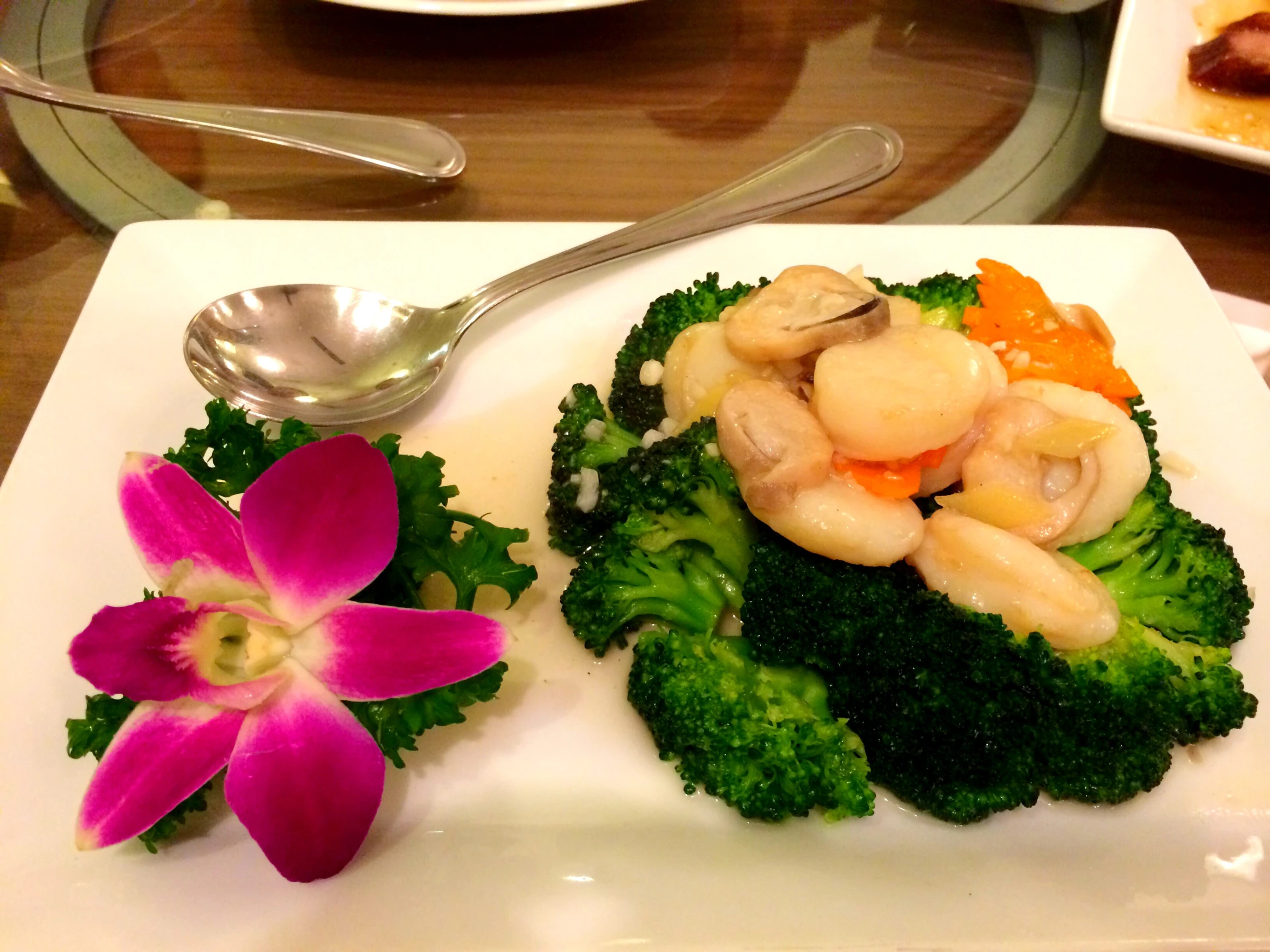 a serving plate with broccoli and mushrooms, and a fork