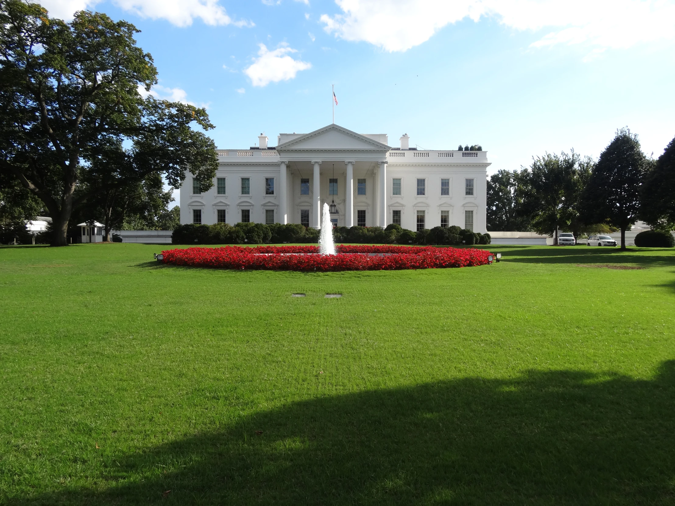 a large white house that has a lot of green grass in front of it