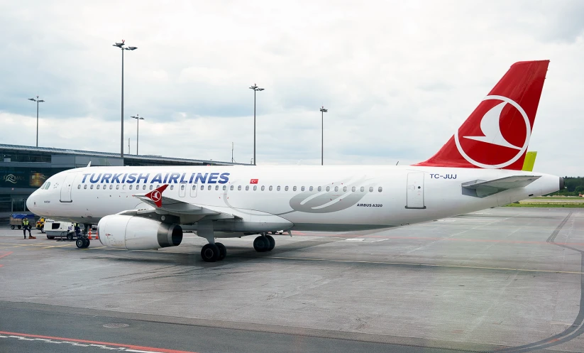 an airplane parked on a runway next to other planes