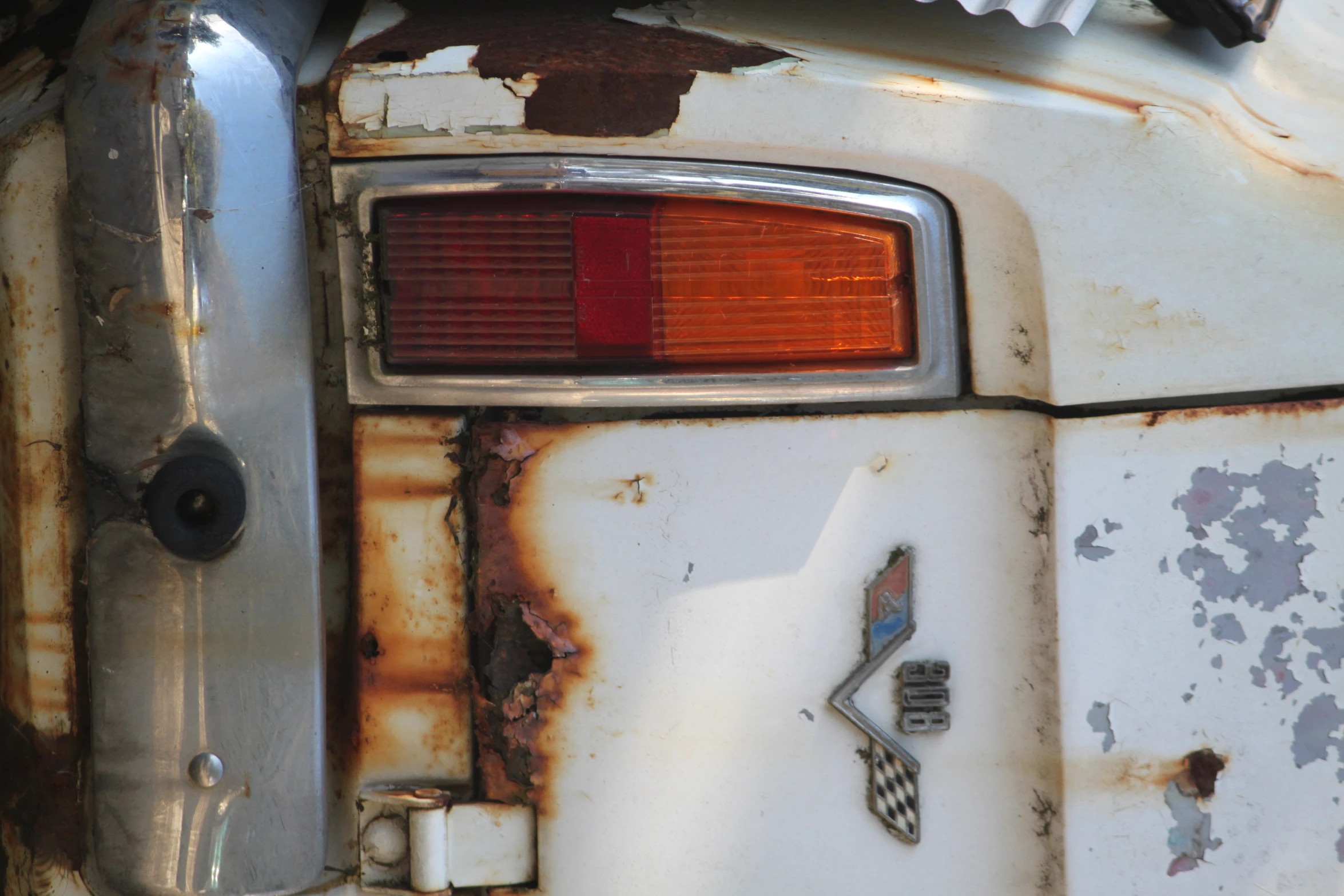 an old rusted out car with a tail light on