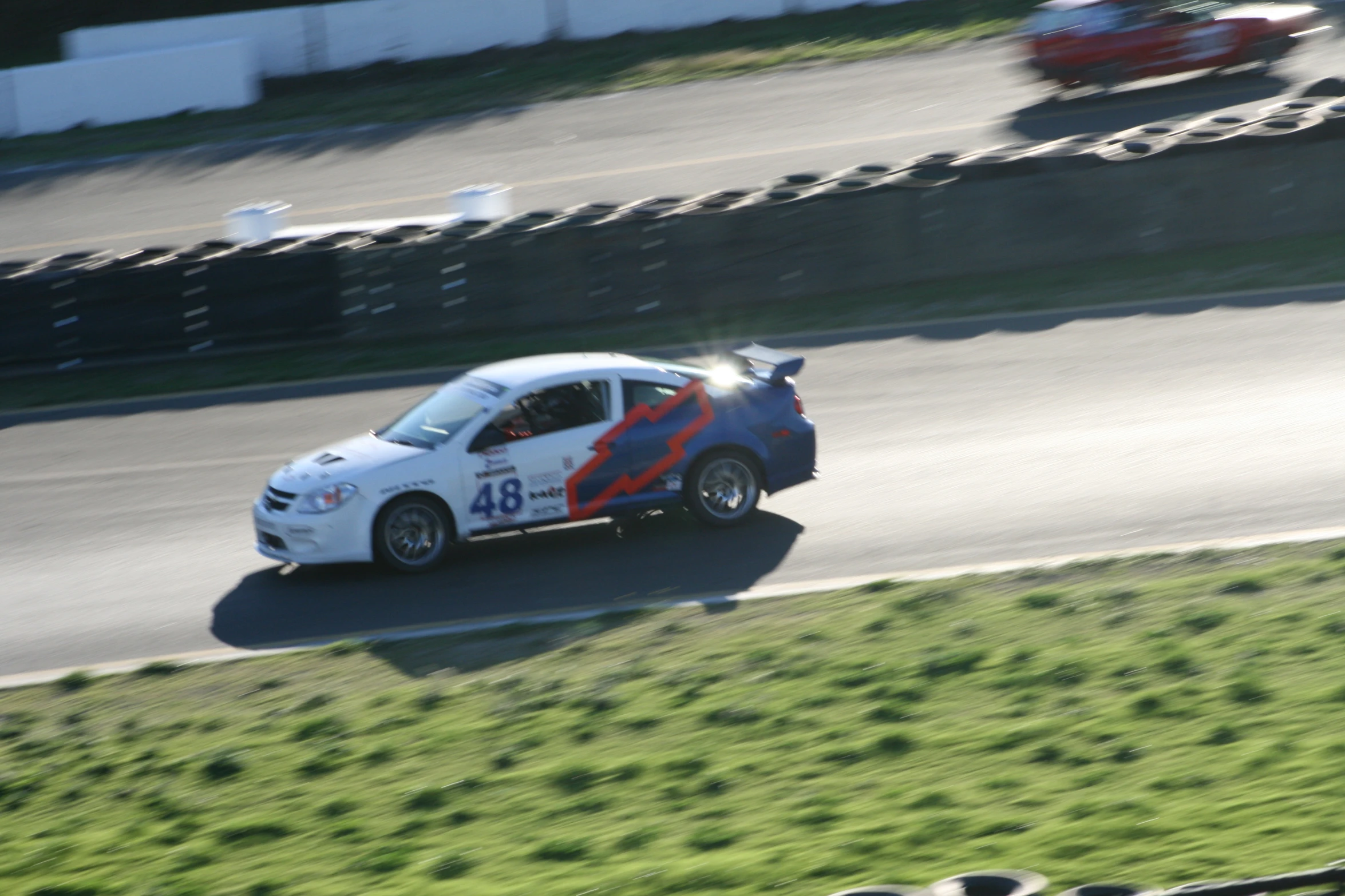an alfa car on a racetrack with a person racing