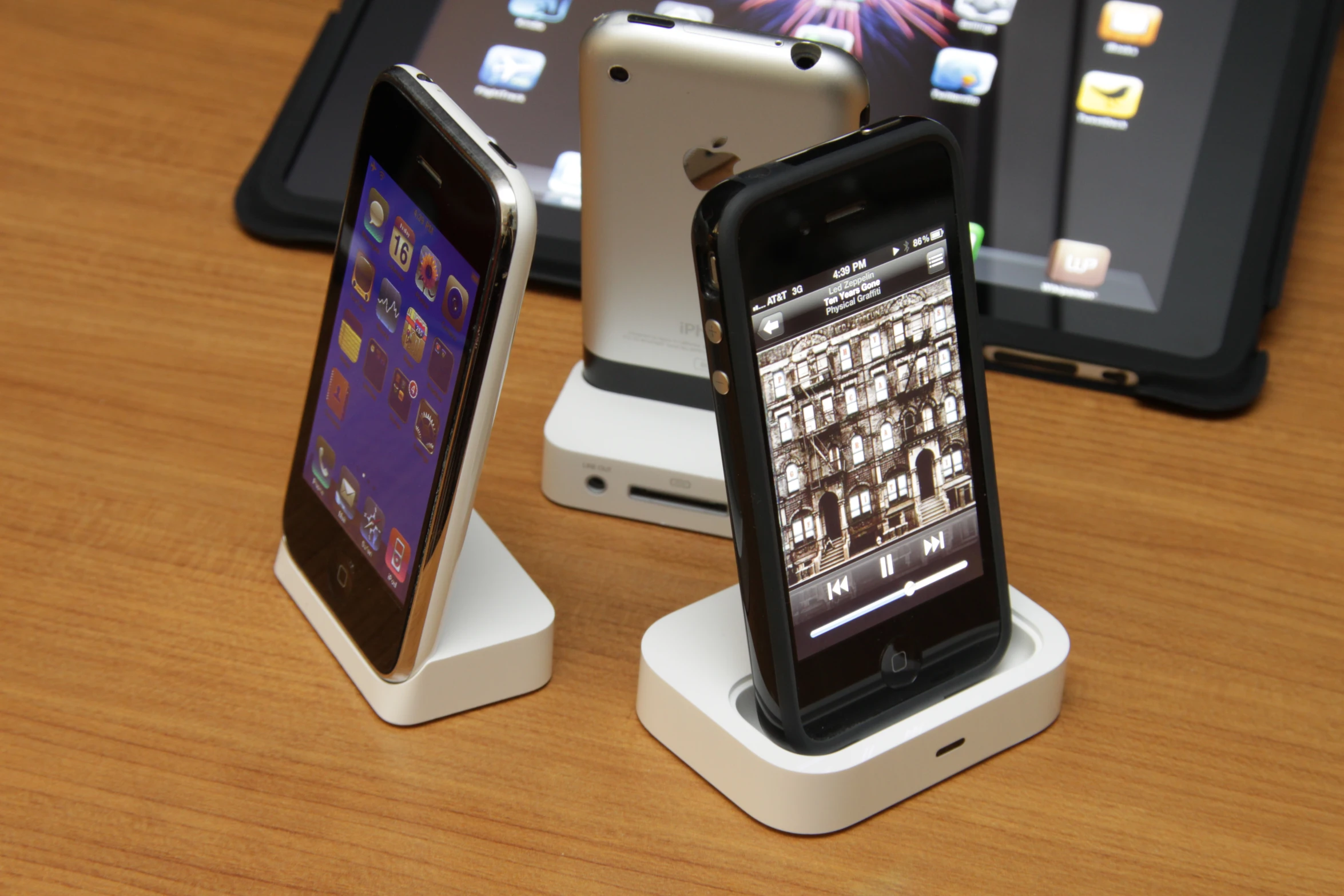 three phones sitting on a table with their charging dock