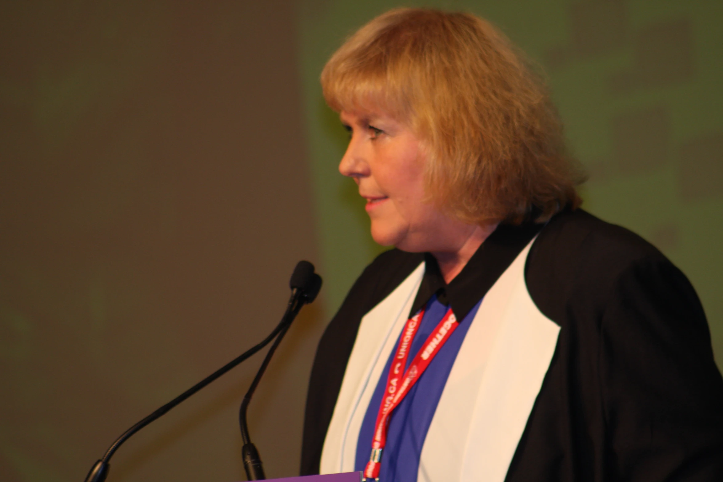 a woman is giving a speech at a podium