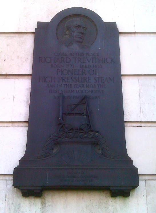 a plaque on the side of a building in black
