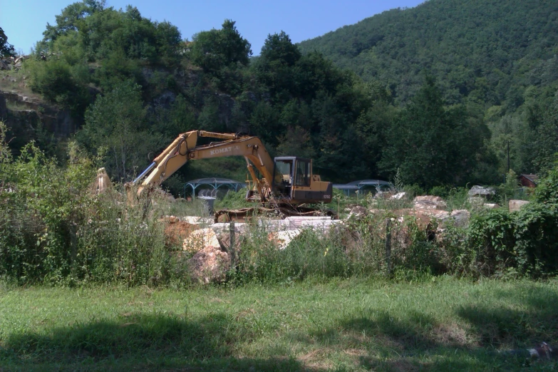 an abandoned building in a field with a bulldozer