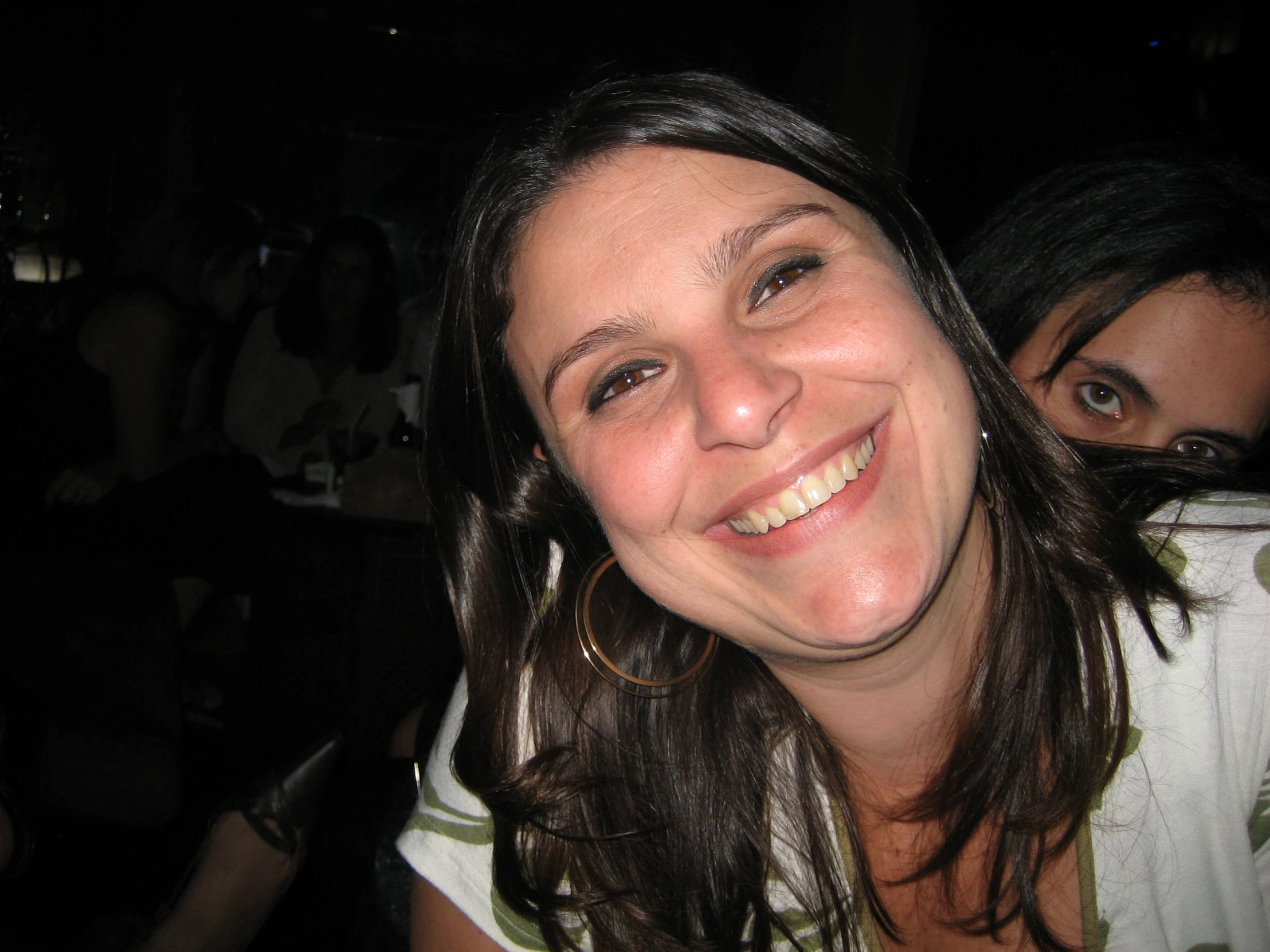 a woman smiling at the camera while sitting