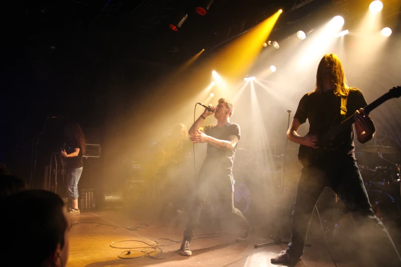 the band the strutors playing on a dimly lit stage