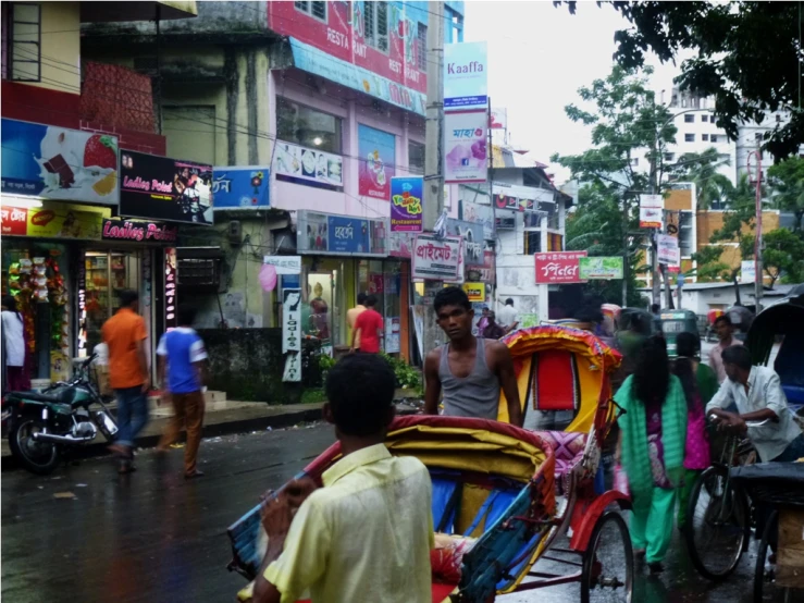 people are walking down a street by a busy road