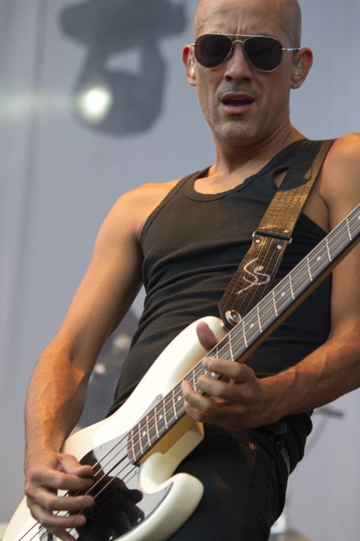 a man in a tank top playing a guitar