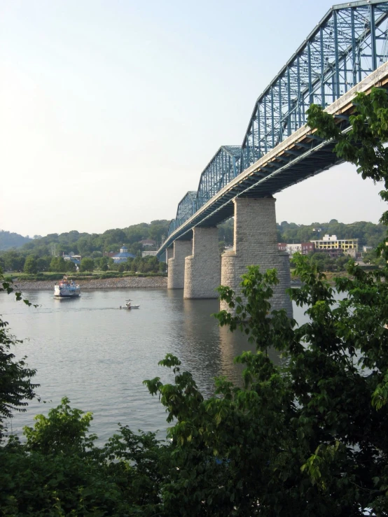 bridge over water and two boats floating under it