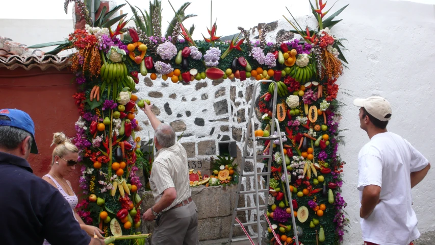 three men are outside next to a decorated archway