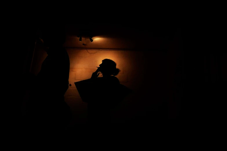 a man in a dark room talking on his cell phone