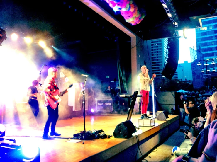 a band playing on a stage with audience watching