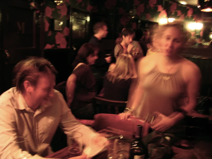 a woman is sitting at a table and looking away from the camera